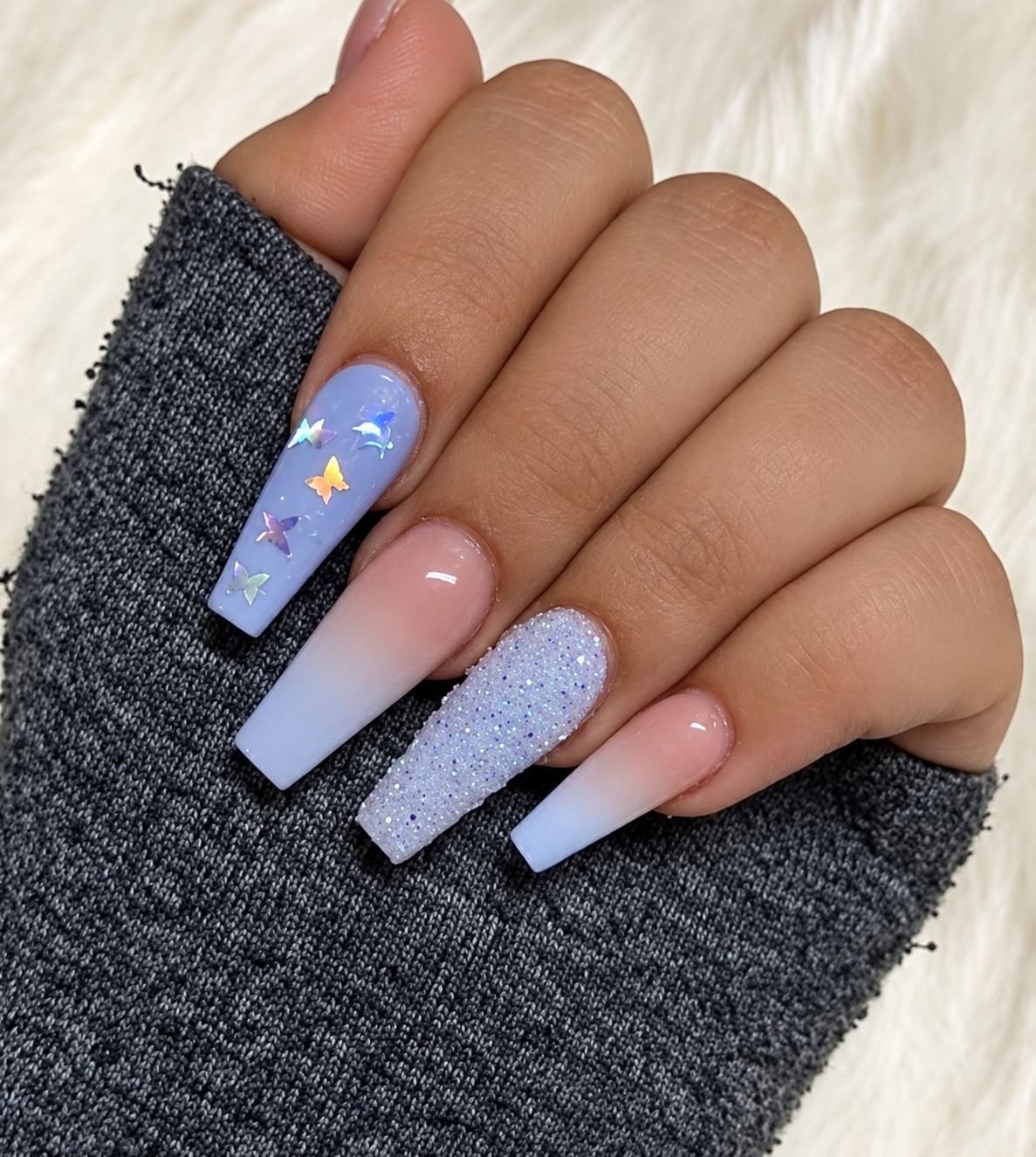 Lavender nails with butterfly and glitter details from the salon’s portfolio